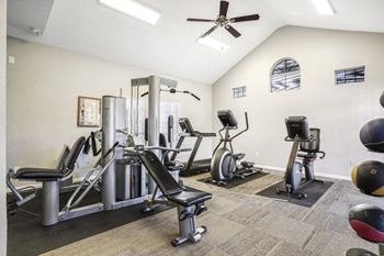 The fitness room has cardio equipment and a ceiling fan