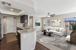 Mesa apartment for rent - A modern kitchen with a white island and a white sofa in the living room. at San Montego Apartments, Mesa