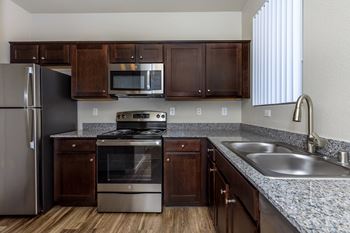 A kitchen with granite counter tops and stainless steel appliances