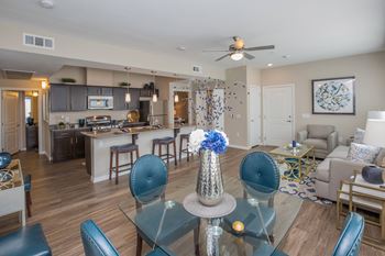 A living room and kitchen with a dining room table and chairs