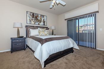A bedroom with a bed and a ceiling fan