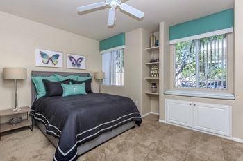 A bedroom with a bed and a ceiling fan