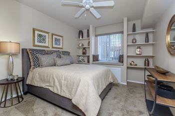 A bedroom with a bed and a ceiling fan