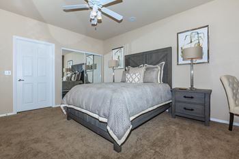 A bedroom with a bed and a ceiling fan