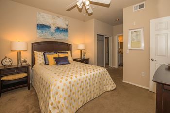 A bedroom with a bed and a ceiling fan