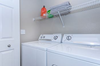 Laundry room with washer and dryer and a shelf