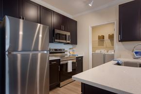 Bradenton apartment for rent - a kitchen with dark cabinets and white countertops  at The Oasis at Manatee River, Bradenton, FL, 34211