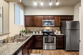 Las Vegas apartment for rent - A modern kitchen with dark wood cabinets and stainless steel appliances.