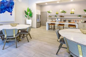 A dining room with tables and chairs and a kitchen