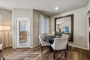 Las Vegas apartment for rent - A dining room with a table set for two and a view of a door with blinds.