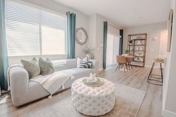 Las Vegas apartment for rent - A living room with a white couch and a round ottoman.