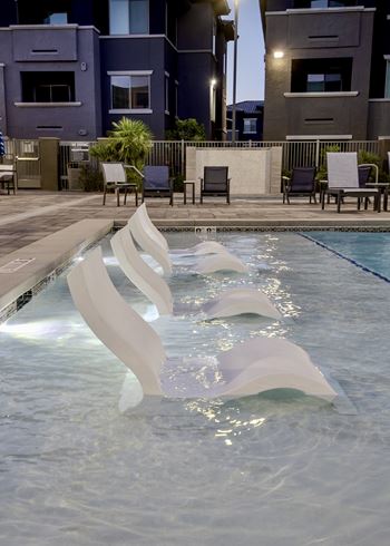 Shallow water sundeck with tanning chairs in swimming water