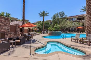 Swimming pool and patio with tables and umbrellas