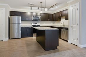 Warwick apartment for rent - a kitchen with stainless steel appliances and dark cabinets