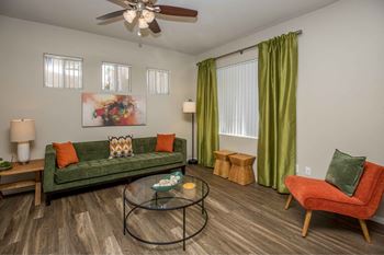 A living room with green couch and orange chairs and a coffee table