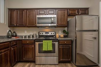 A kitchen with stainless steel appliances and wooden cabinets