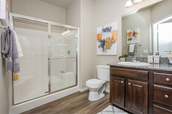 A bathroom with a shower and a sink and a toilet