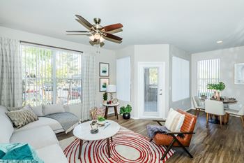 A living room with a couch and a chair and a ceiling fan