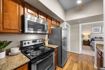 Henderson apartment for rent - A kitchen with a black stove top oven and a black microwave above it.