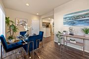 Las Vegas apartment for rent - A dining room with a glass table and blue chairs. at The Fairways by Picerne Apartments, Las Vegas, NV, 89141