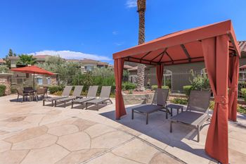 A patio with a red canopy and chairs.