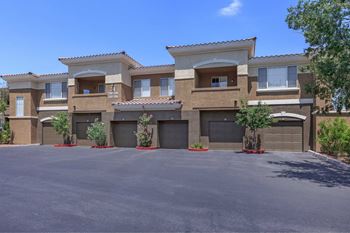 An empty driveway in front of a house with garage doors