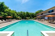 Warwick apartment for rent - A large swimming pool surrounded by lounge chairs and umbrellas.