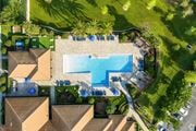 Ocoee apartment for rent - A swimming pool surrounded by a grassy area and a few trees.