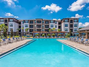 Zephyrhills apartment for rent - A large swimming pool in front of apartment buildings.