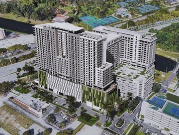 North Miami Beach apartment for rent - A large, modern building with a green roof is surrounded by a pool and palm trees.