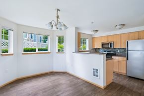 Olympia apartment for rent - York dining room and kitchen with four windows and wood cabinets at Abbey Rowe Apartments in Olympia, WA