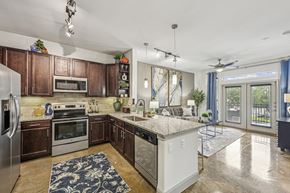 Houston apartment for rent - Kitchen view showing a spacious layout with dark wood cabinets and pendant lighting at Allusion at West University apartments in Houston, TX