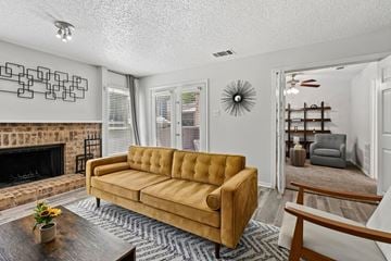 Plano apartment for rent - A living room with a yellow couch and a fireplace.