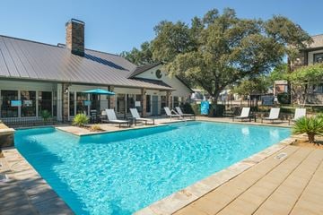 Denton apartment for rent - A swimming pool with a house and trees in the background.