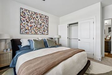 Waco apartment for rent - A bedroom with a large bed and a painting on the wall.