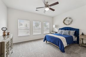Austin apartment for rent - B3 carpeted bedroom bed, windows, and a ceiling fan at Creekside on Parmer Lane Apartments in Austin, TX