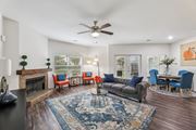 Austin apartment for rent - B3 living room with a couch, ceiling fan, windows, and a fireplace at Creekside on Parmer Lane Apartments in Austin, TX