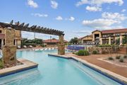 Austin apartment for rent - A swimming pool surrounded by lounge chairs at Creekside on Parmer Lane Apartments in Austin, TX