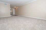 Shreveport apartment for rent - A spacious living room with beige walls and carpeted floor  at The Creole Apartments in Shreveport, LA