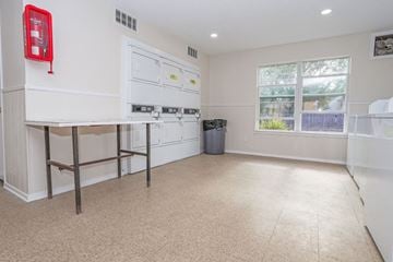 Shreveport apartment for rent - A kitchen with white cabinets and a red fire extinguisher on the wall.