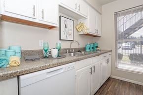Bossier City apartment for rent - A kitchen with white cabinets and a granite countertop at The Drake in Bossier City, LA
