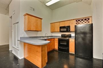 Dallas apartment for rent - A kitchen with black appliances and wooden cabinets.