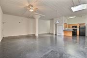 Dallas apartment for rent - A spacious room with a ceiling fan and a kitchenette in the corner.