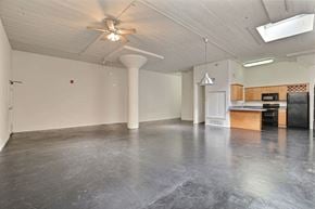 Dallas apartment for rent - A spacious room with a ceiling fan and a kitchenette in the corner.