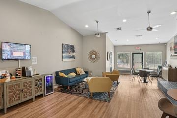 Sandy Springs apartment for rent - A living room with a blue couch and a television on the wall.