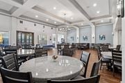 Richardson apartment for rent - A large event room with round tables and chairs at Encore at Buckingham Apartments in Richardson, TX