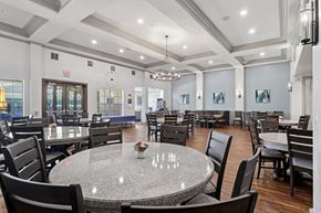 Richardson apartment for rent - A large event room with round tables and chairs at Encore at Buckingham Apartments in Richardson, TX