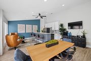 Irving apartment for rent - A modern clubhouse with a dining table and chairs, a kitchen, and a TV at Estelle Creek North Apartments in Irving, TX