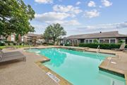 Irving apartment for rent - A sparkling pool with trees and the leasing office at Estelle Creek North Apartments in Irving, TX