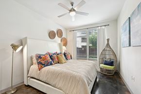 Houston apartment for rent - Model bedroom with a bed and a ceiling fan at Harlow River Oaks in Houston, TX